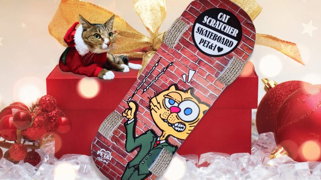 キジトラ猫のレオが、クリスマス飾りの前でスケートボード型の爪とぎ(CAT SCRATCHER SKATEBOARD PERIS)に乗ってくつろいでいる写真。